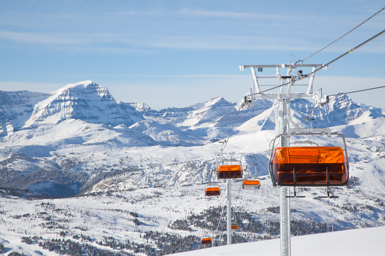 TeePee Town LX-lift. Deze snelle skilift is voorzien van stoelverwarming en een hip uitziend windscherm van oranje plexiglas. Echte bubble-chairs!